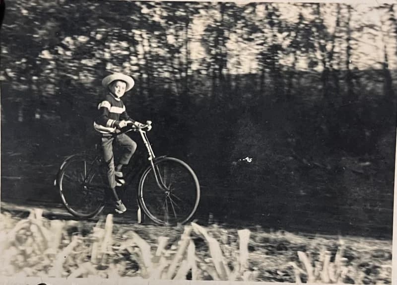 Kisfiú biciklizik a tanya mellett 