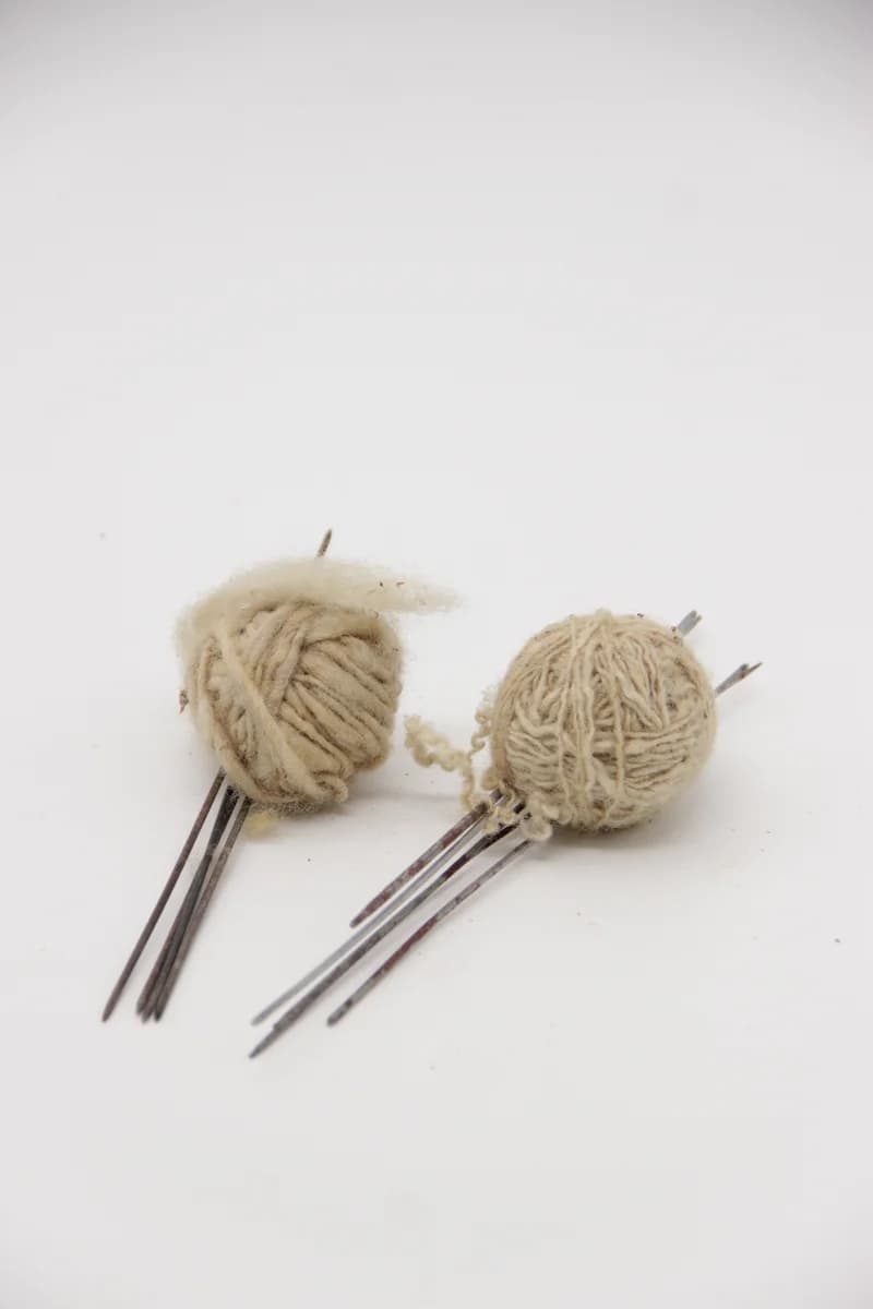 Fémtűk és gyapjúgombolyagok