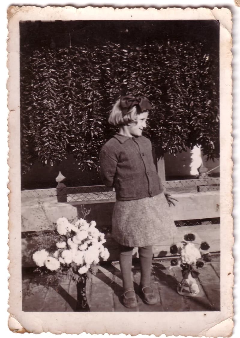 Kislány paprikafűzérek előtt